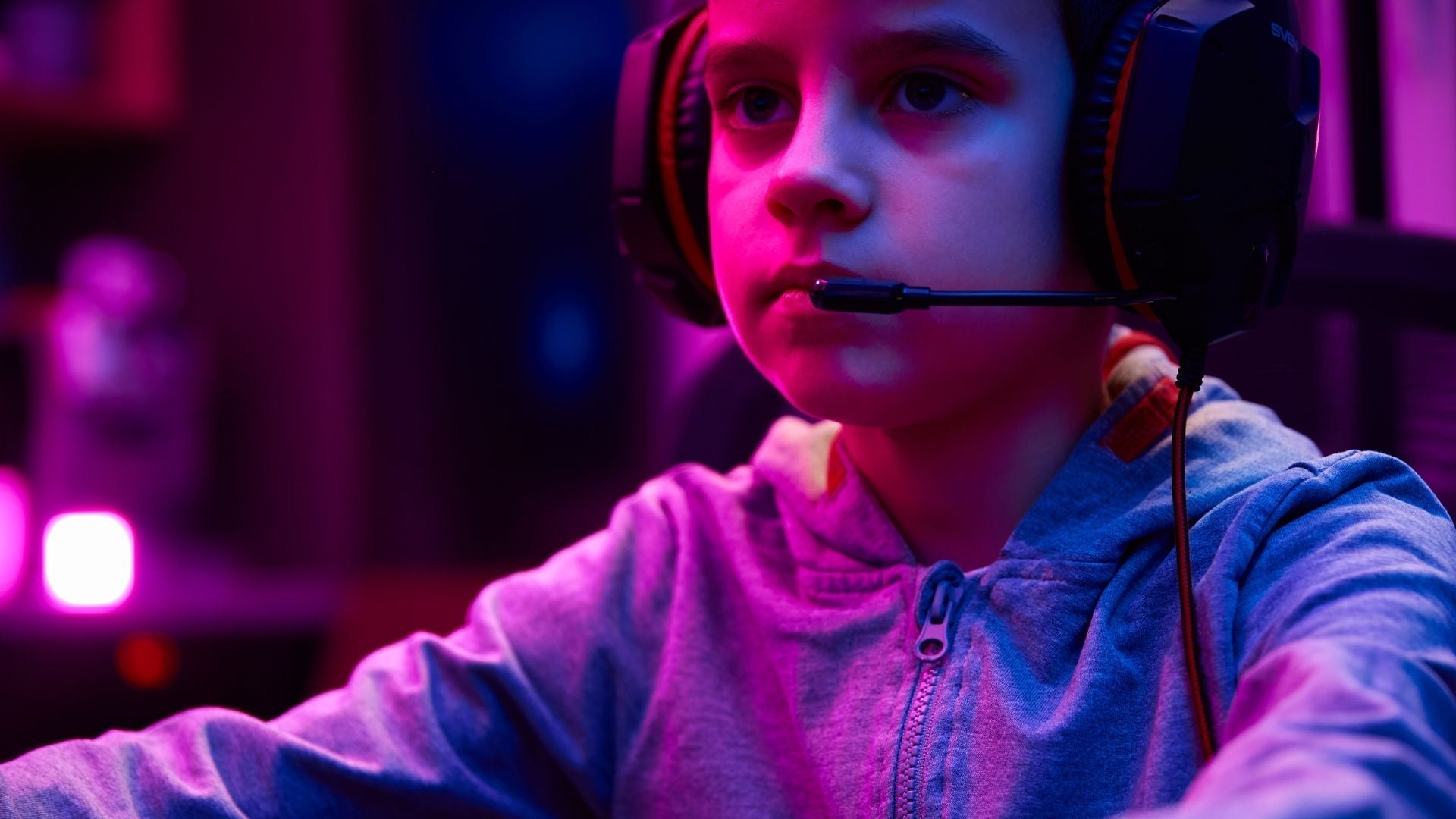 Boy who loves gaming, concentrated on his screen and headset