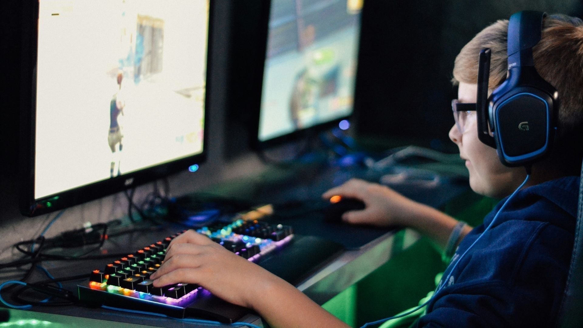 Boy playing video games on computer unaware of scams