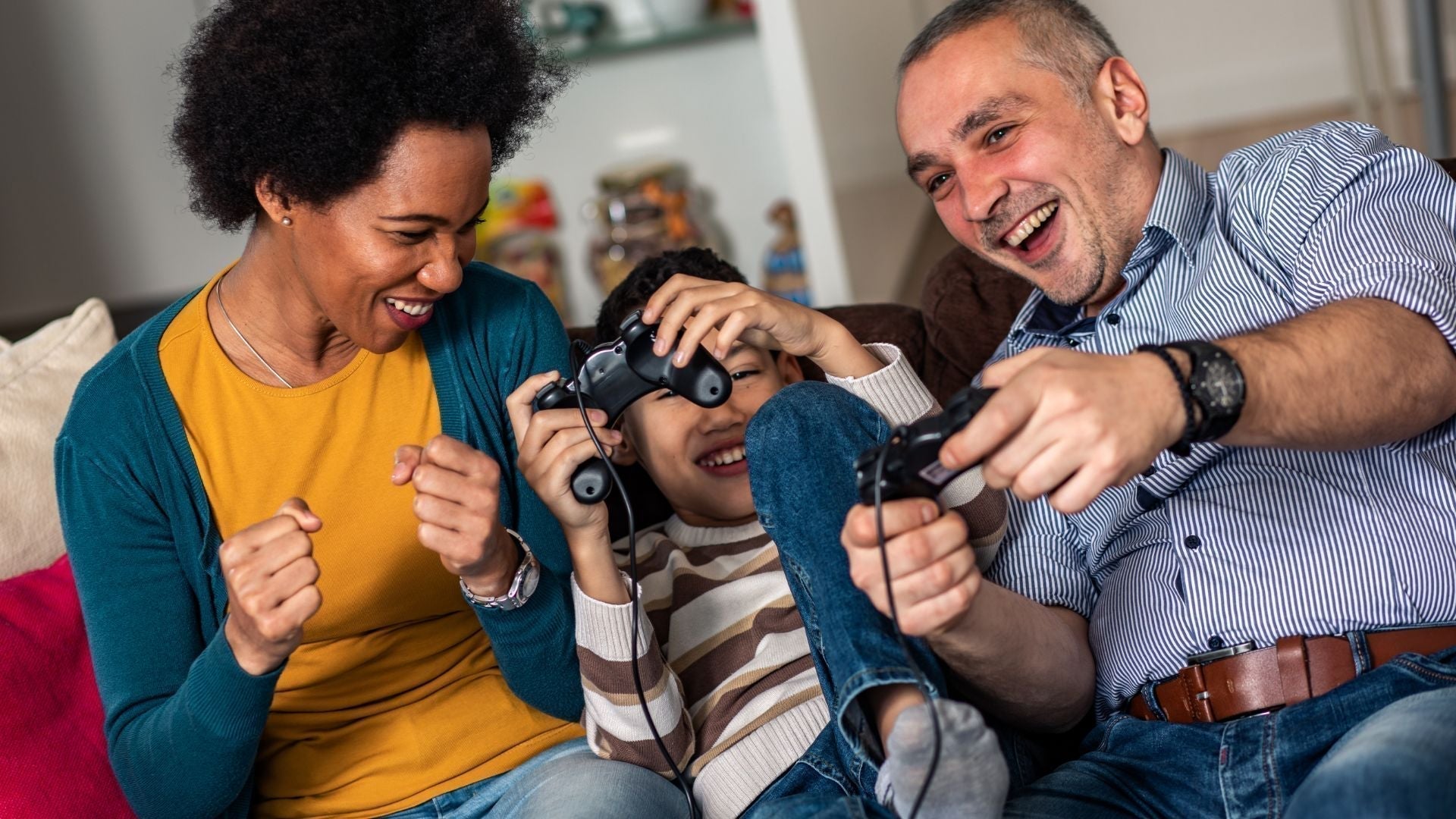 Happy family laughing while playing video games together