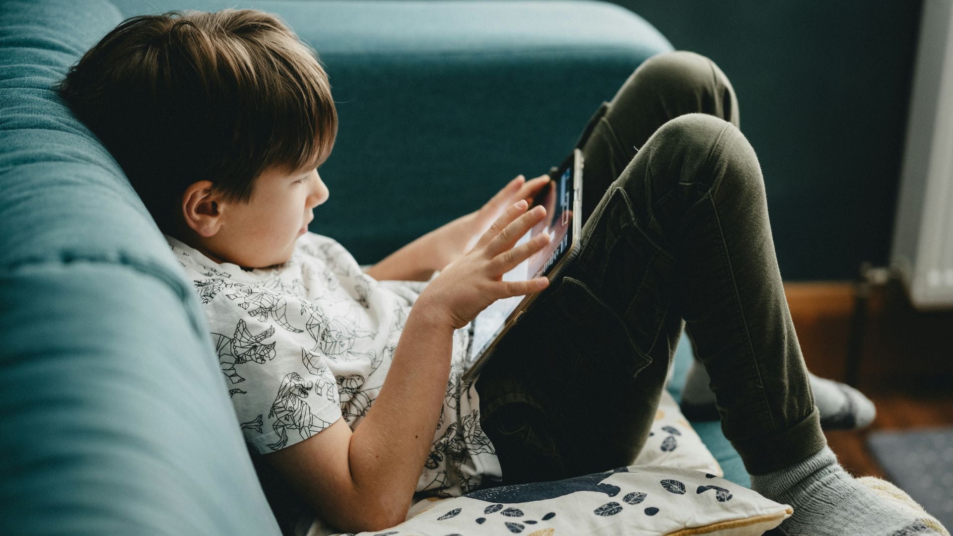 Kid playing on his tablet not seeing the scams he's exposed to