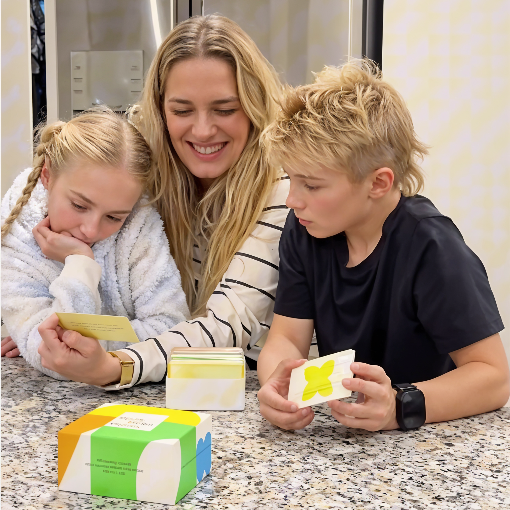 Woman with two children in a kitchen setting, interacting with the Raising Digital Citizens Kit